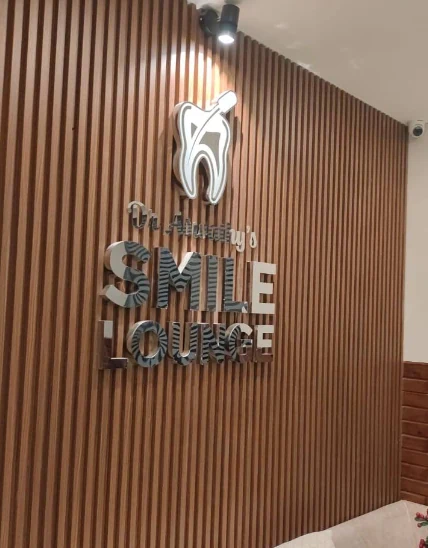 Smile Lounge logo on warm wood wall
